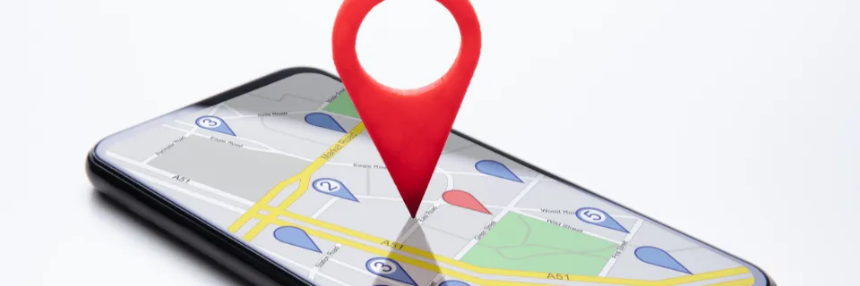 Googleマップが表示されたスマートフォンと地図ピン