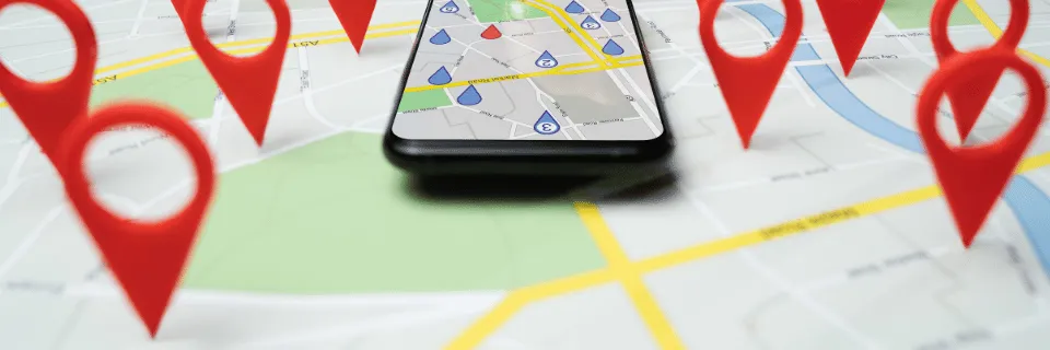 Googleマップ上に並ぶ口コミのピンとスマートフォン